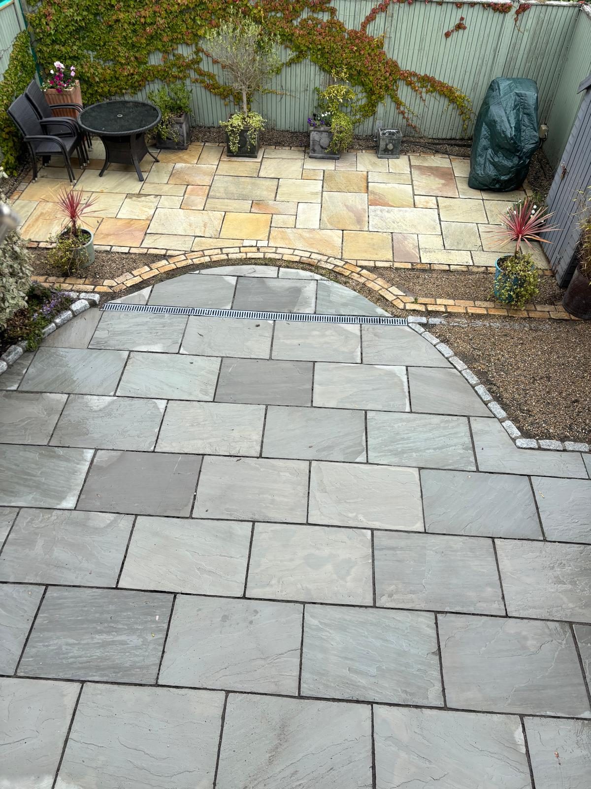 The same curved sandstone patio after cleaning — bright two-tone stone restored