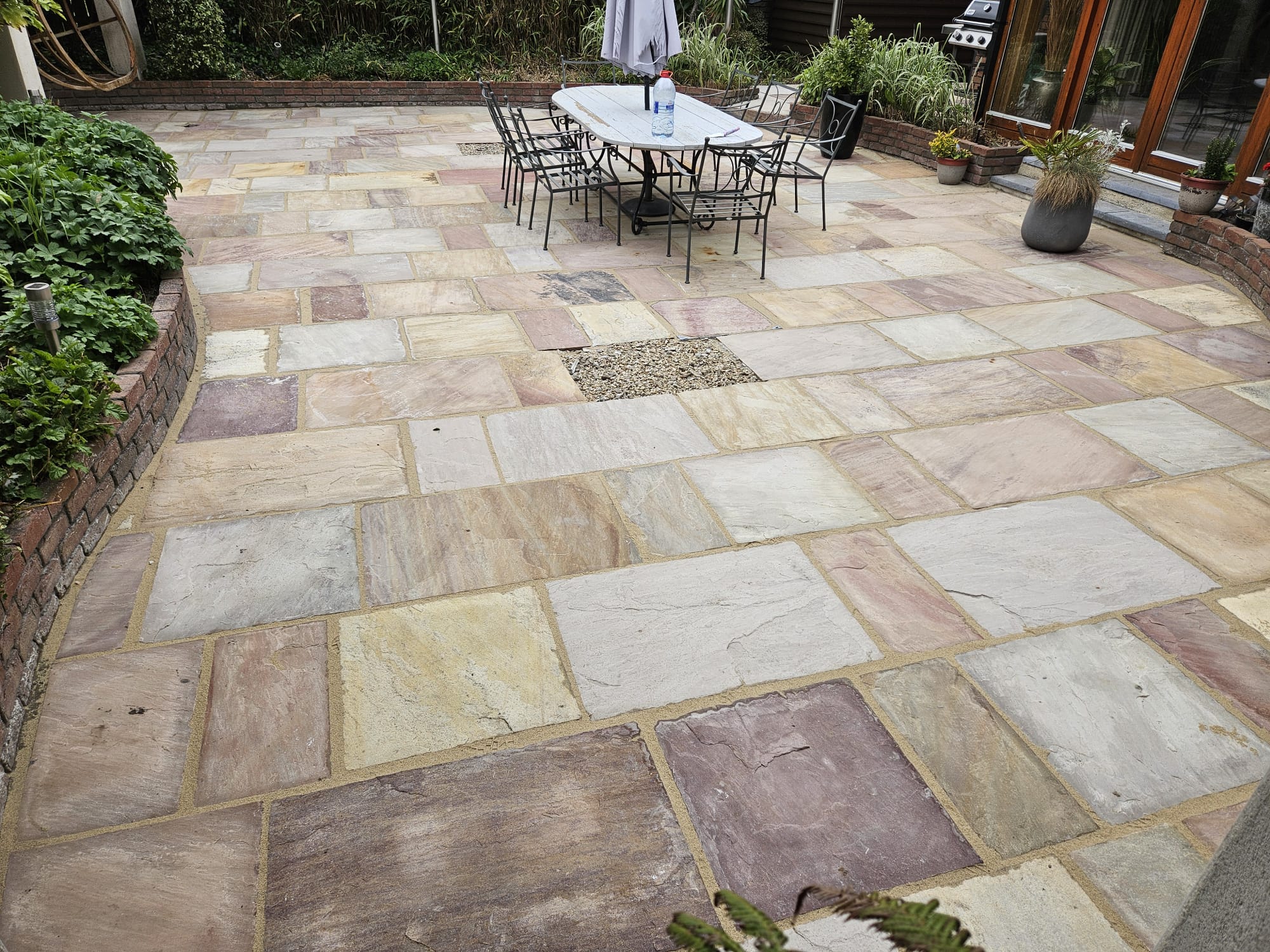 The same sandstone patio after cleaning and re-jointing — colours restored