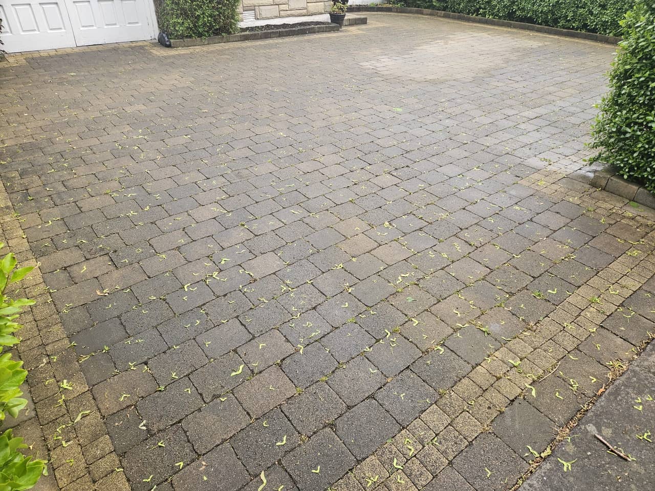 Block paving driveway before cleaning, grime hiding the colours