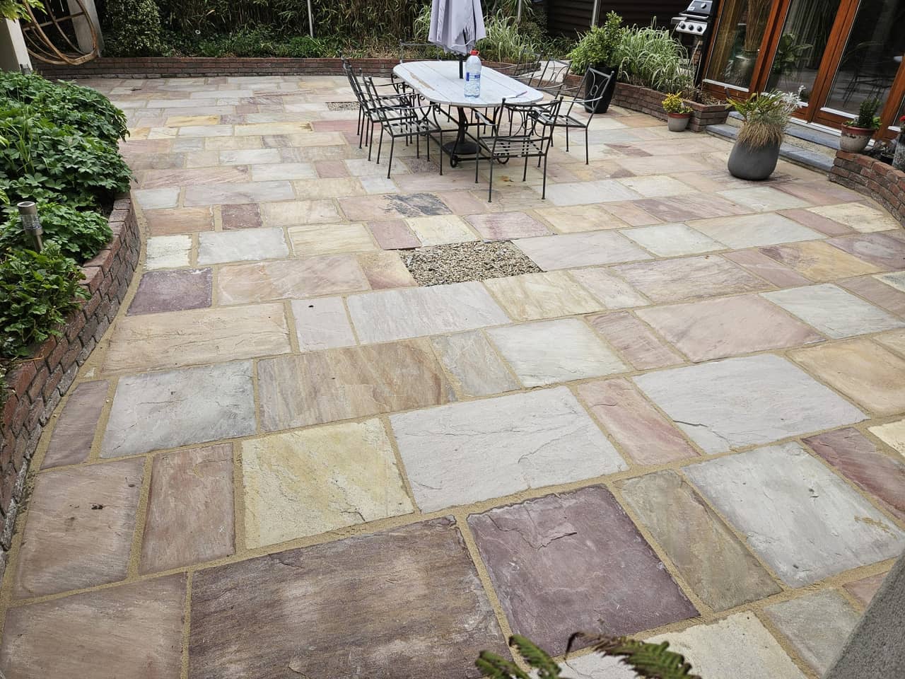 The same sandstone patio after cleaning and re-jointing, colours restored